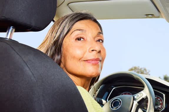 Driver in the driver's seat of a car looking backwards.