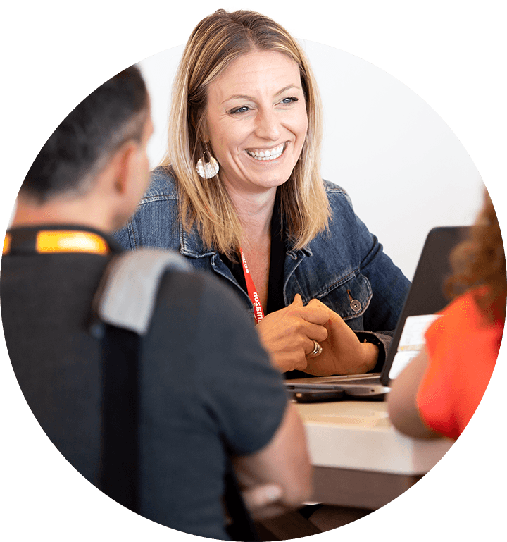 Friendly Amazon Selling Partner Summit employee helping a man and woman sitting in front of her